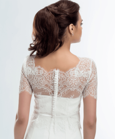 Sett prikken over i en med denne Nydelige Blondetoppen til Brud med lange armer og knapper i ryggen. Nydelig blondekappe nederst hele veien rundt. Ivory/Krem farget passer de aller fleste brudekjoler i Ivory og kremfarge. Vintage blondetopp med kappe E