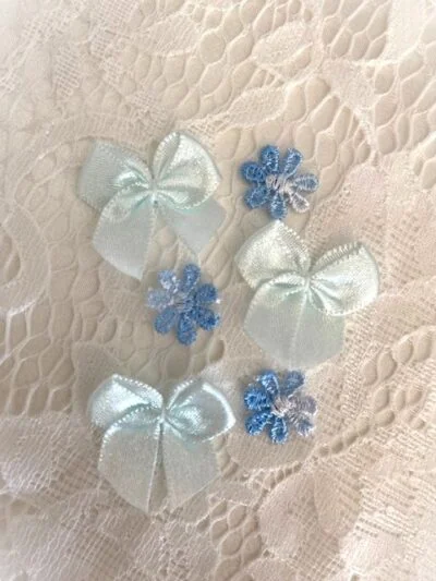 Små blå blomster til å sy på dåpskjole og dåpslue